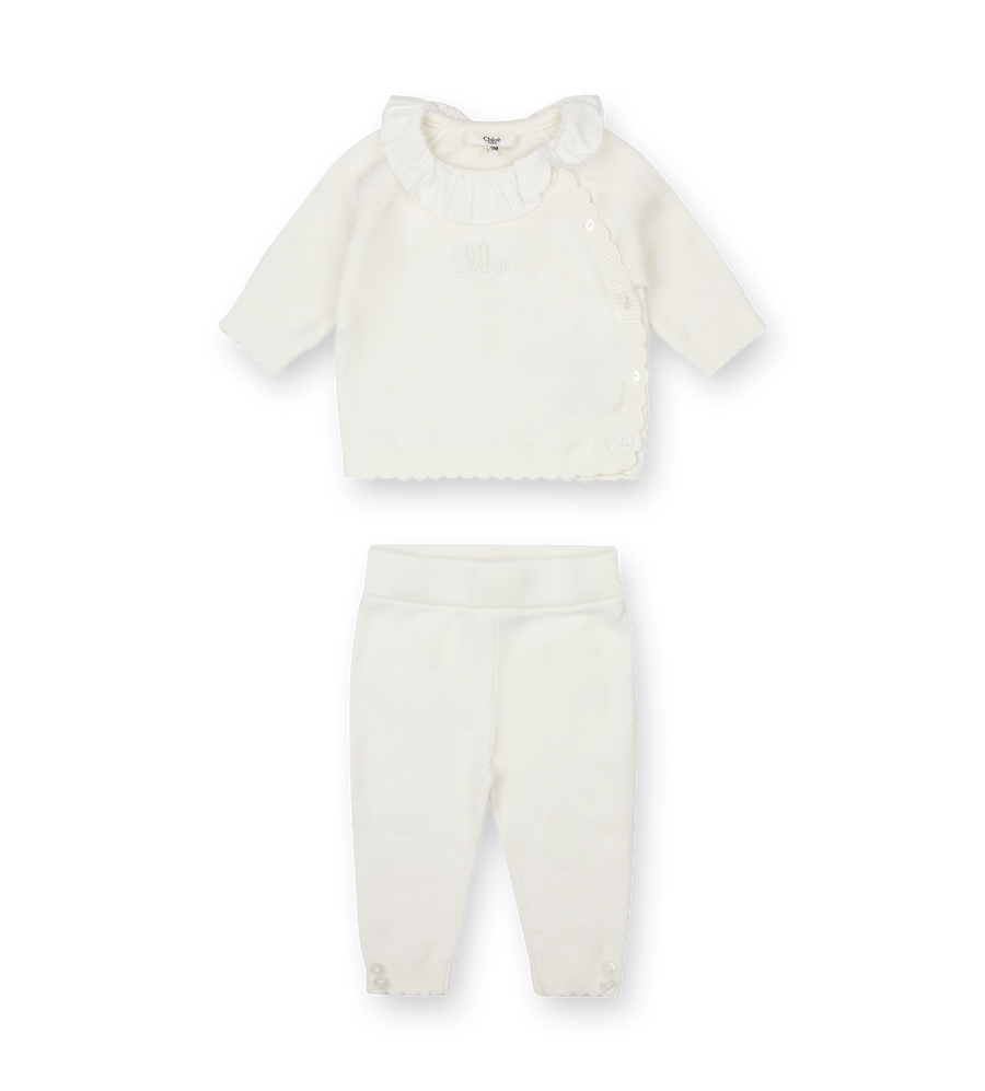 White baby outfit with shirt and pants on a white background