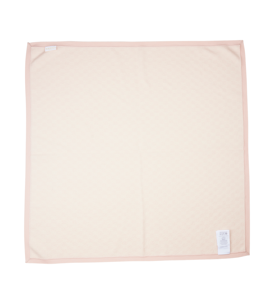 Beige blanket with a small label on a white background
