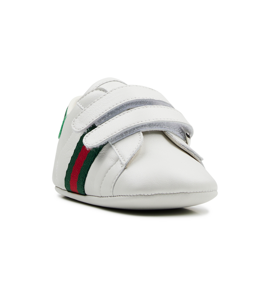 white baby shoe with green and red stripes