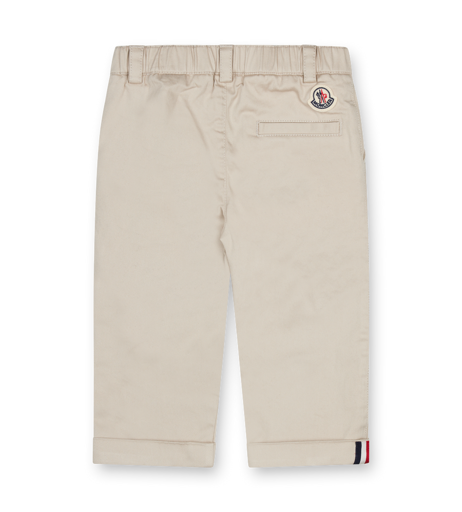 Beige pants with a brand logo on a white background