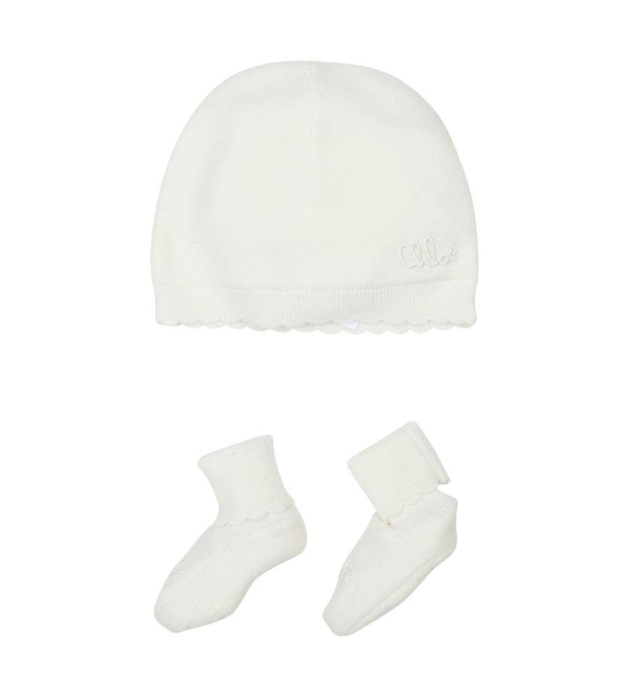White baby hat and socks set on a white background