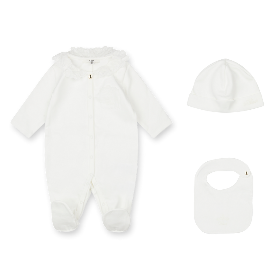White baby onesie, hat, and bib set on a white background