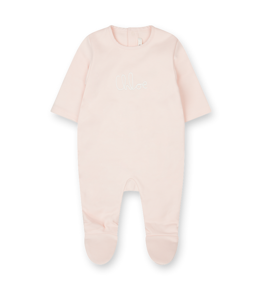 Baby onesie with feet in light pink on a white background
