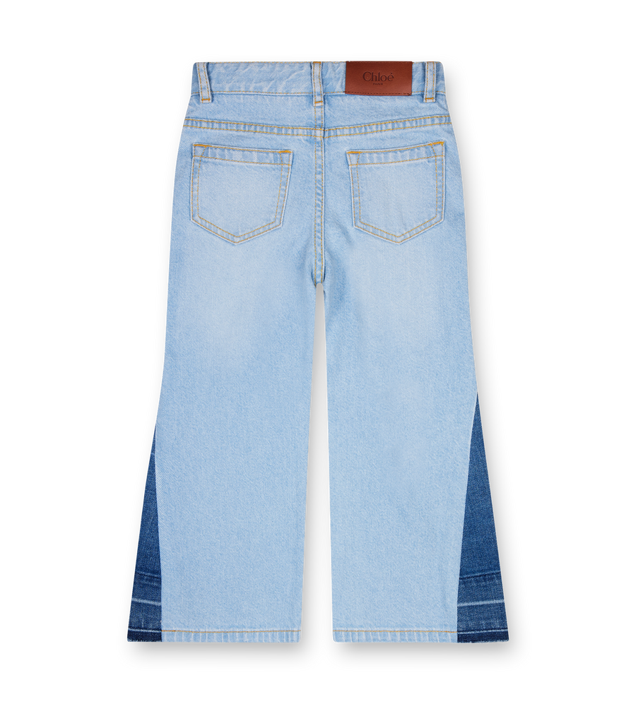 Light blue jeans with a brown belt on a white background