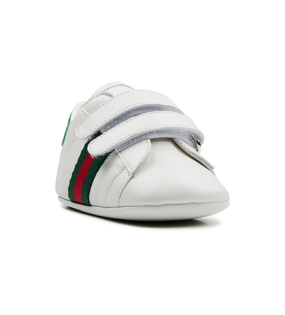 white baby shoe with green and red stripes 