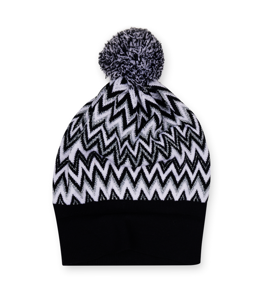 Black and white zigzag patterned beanie with a pom-pom on a white background