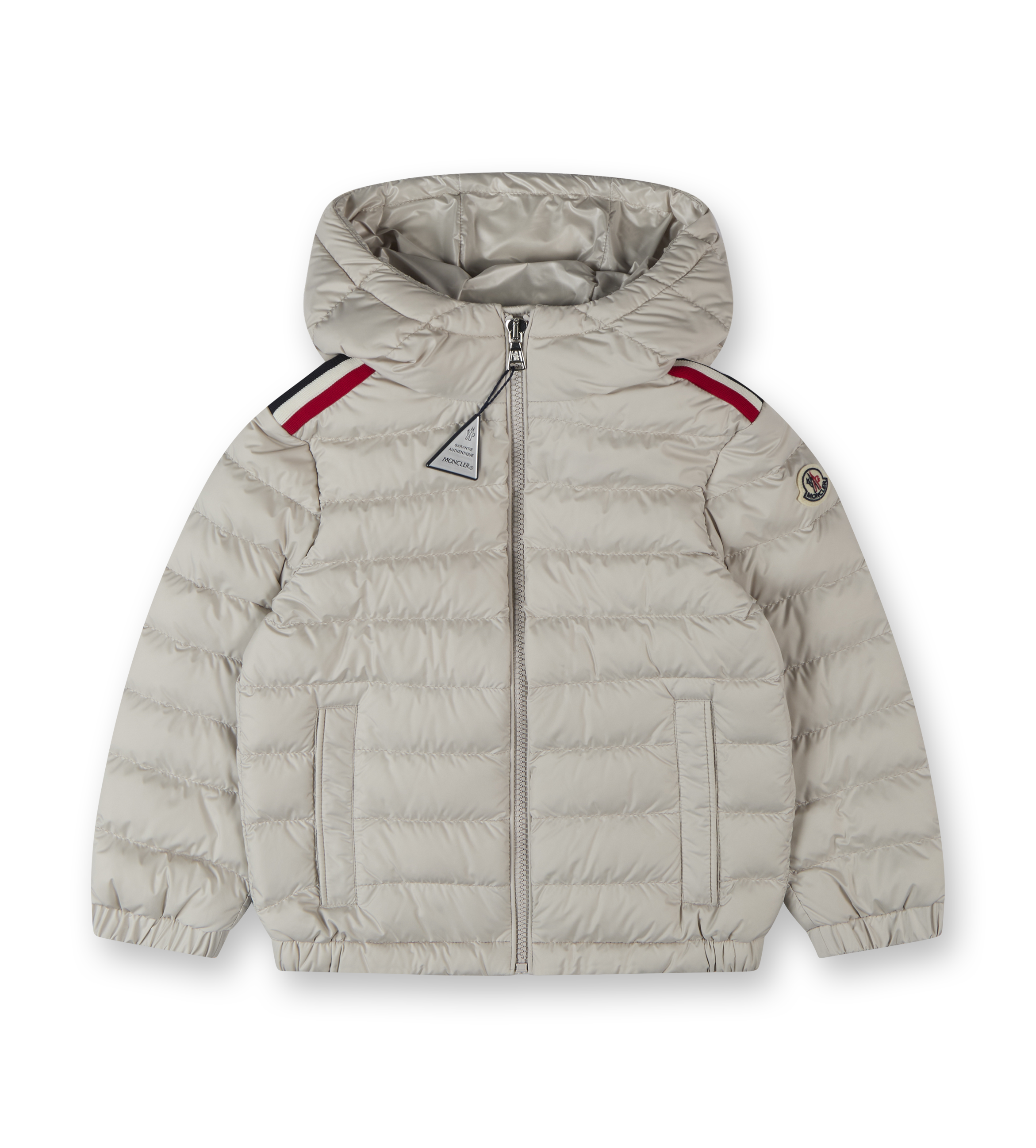 A beige Moncler hooded down jacket for boys with red trim on the shoulders and a zip closure.