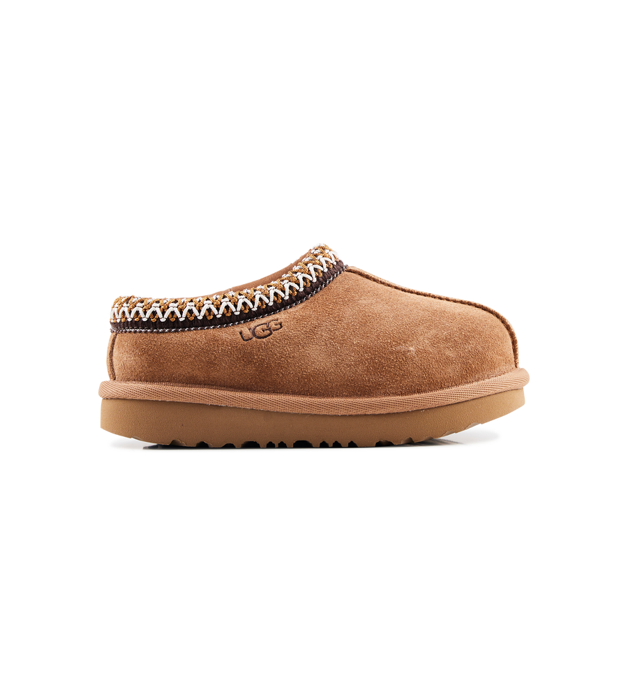 Brown UGG slipper with decorative trim on a white background