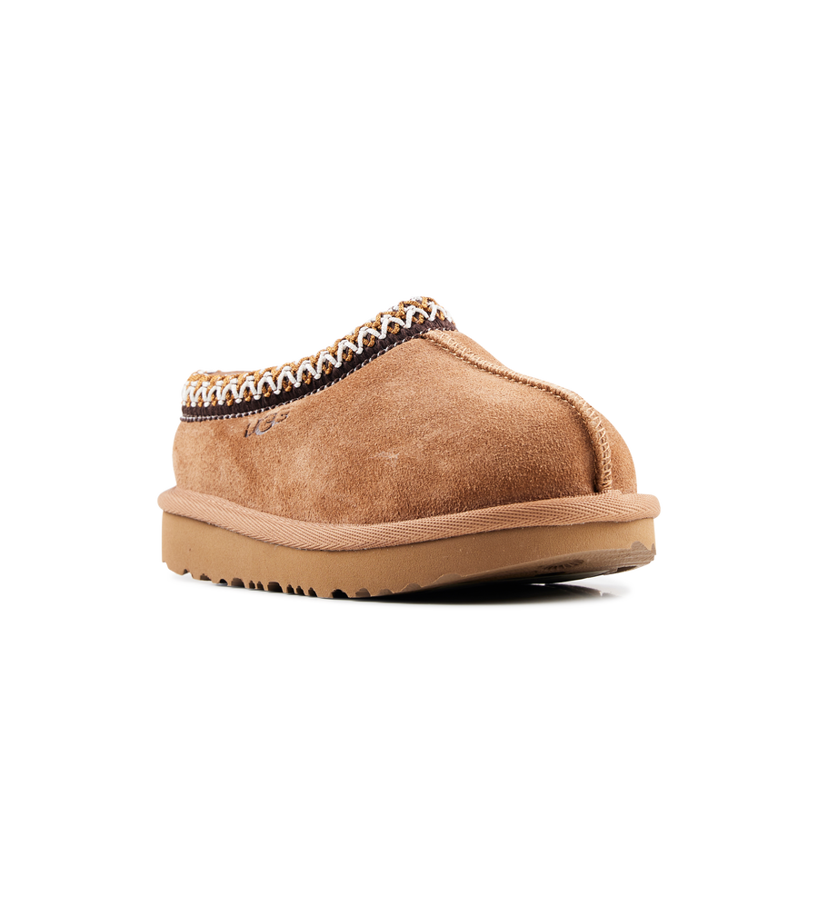 Tan slipper with textured trim on a white background