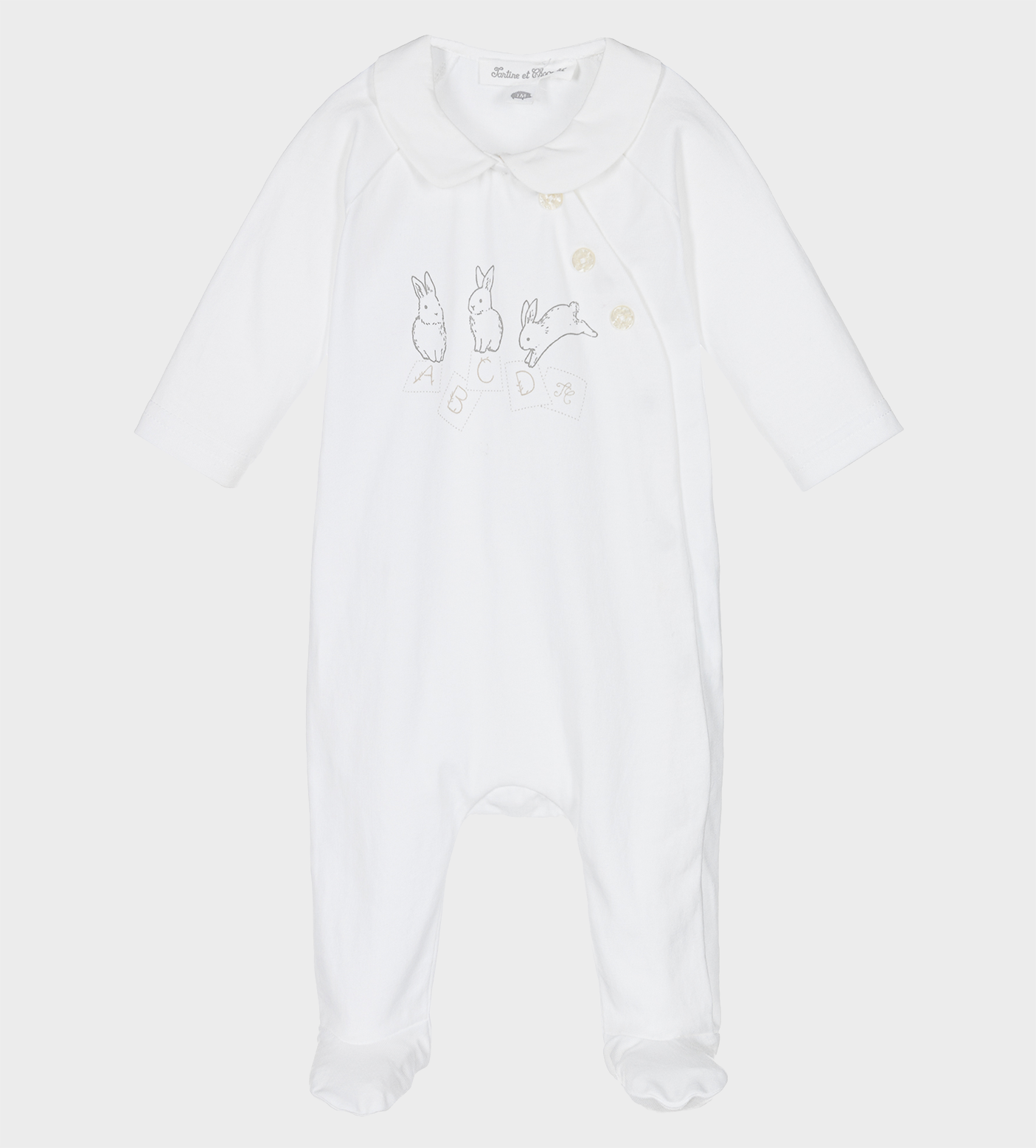 White bodysuit with graphic print to the front, featuring a Peter Pan collar and off-centre front button fastening. It has long sleeves and covers the foot.